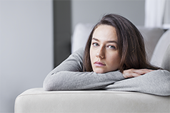 illusztráció a Hogyan enyhítsük a háború okozta szorongásunkat című cikkhez - a fotón egy nő fekszik a kanapén